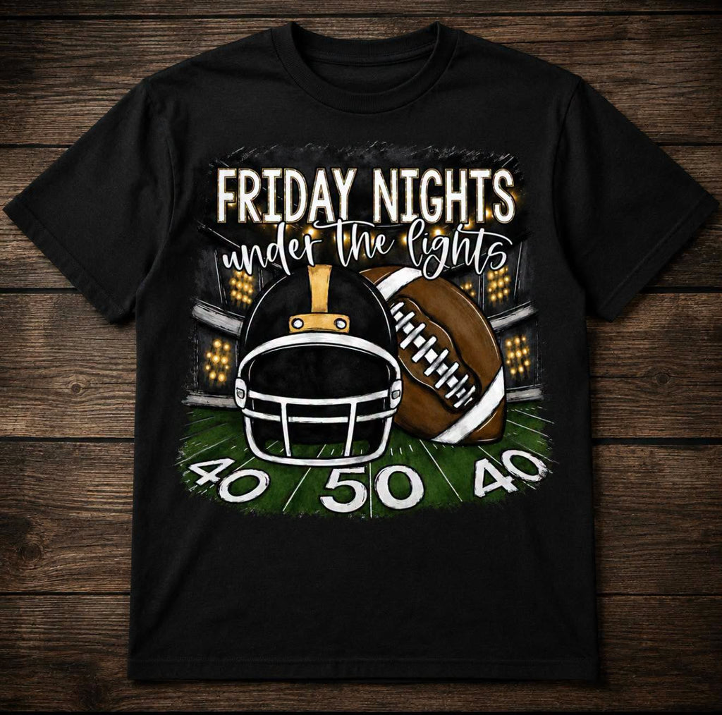 Shirt with Friday Nights Under the Lights wording with a football and helmet on the football field at the 50 yard line with lights in the background.