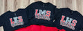 A collection of LHS Wolves t-shirts in black and red, featuring various team graphics and logos, arranged on a light wood floor.
